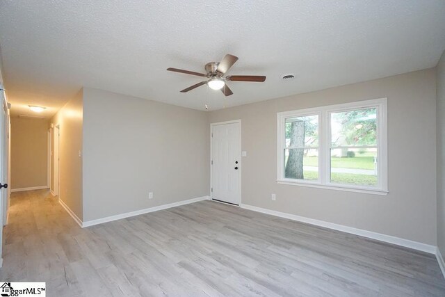 spare room featuring light hardwood / wood-style floors, a textured ceiling, and ceiling fan