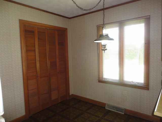 unfurnished bedroom featuring ornamental molding and a closet