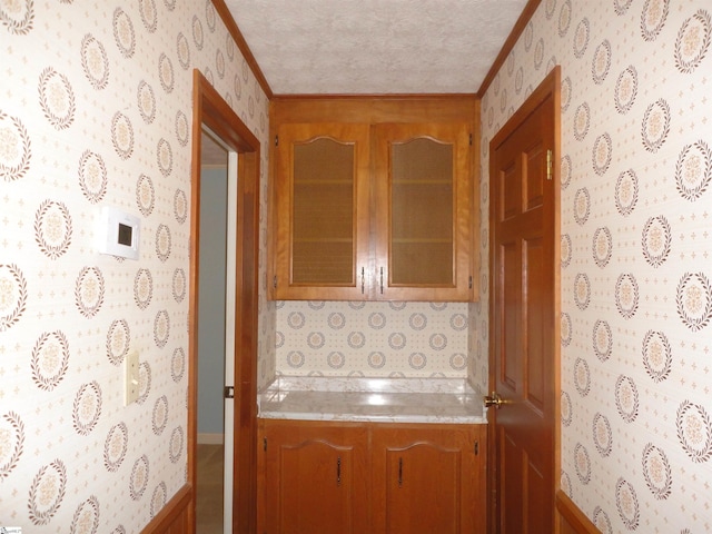 kitchen featuring crown molding and a textured ceiling