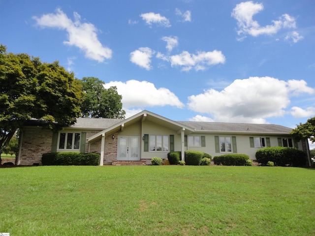 ranch-style home featuring a front lawn and french doors