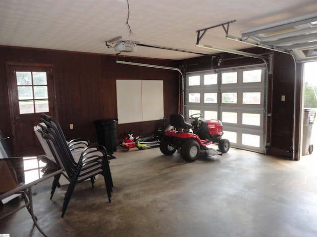 garage featuring a garage door opener and wooden walls