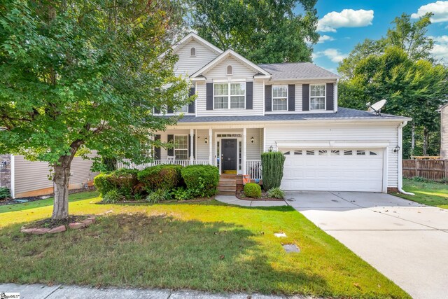 view of front of home featuring a garage, a porch, and a front lawn