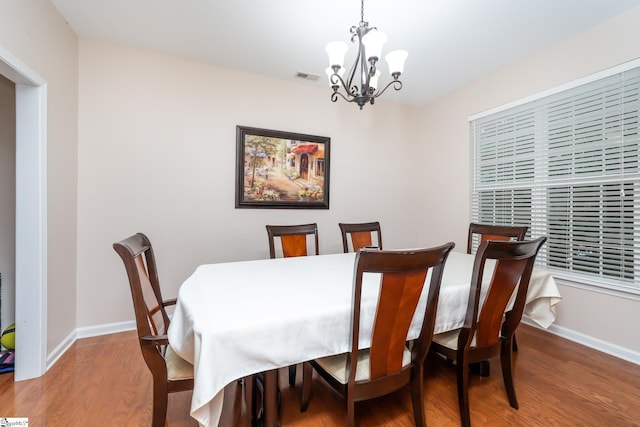 dining room with wood-type flooring and a chandelier