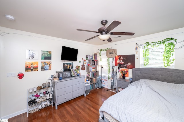 bedroom featuring multiple windows, dark hardwood / wood-style floors, and ceiling fan