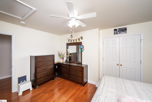 bedroom with wood-type flooring, ceiling fan, and a closet