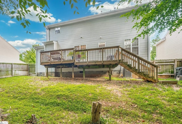 rear view of property with a wooden deck and a lawn