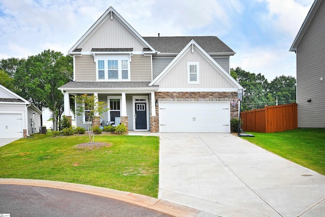 craftsman house featuring concrete driveway, fence, stone siding, and a front yard