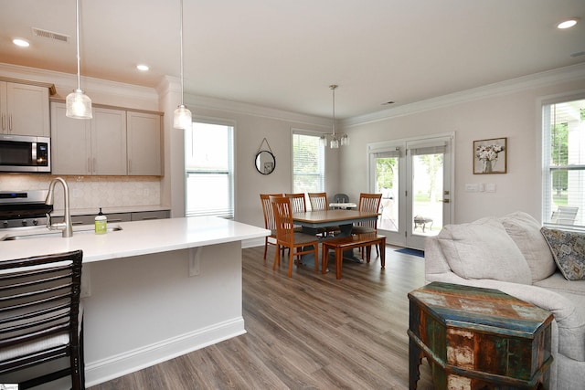 kitchen featuring stainless steel microwave, wood finished floors, visible vents, and a healthy amount of sunlight