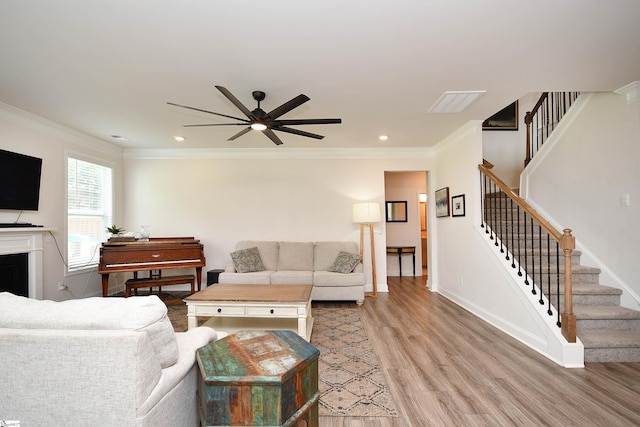 living room with light hardwood / wood-style flooring, ceiling fan, and ornamental molding