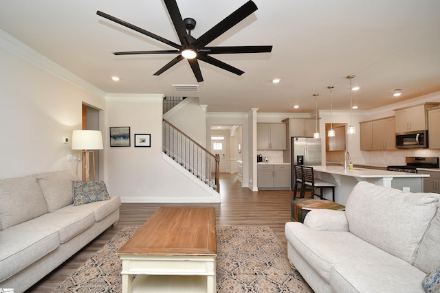 living room featuring stairway, crown molding, light wood finished floors, and recessed lighting
