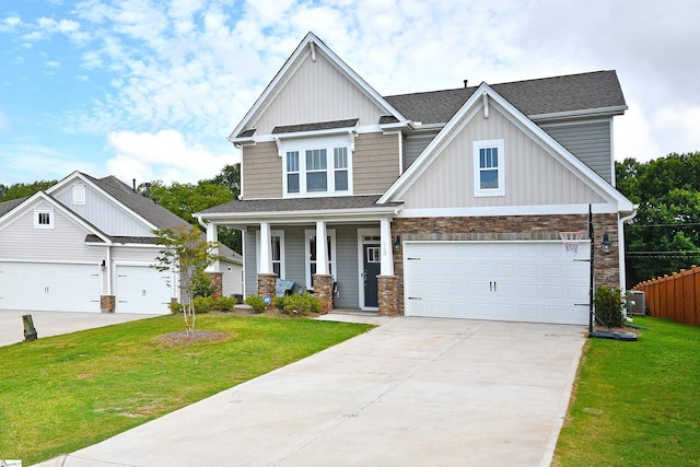 craftsman-style home with a porch, a front lawn, stone siding, and concrete driveway