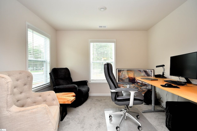 carpeted office space featuring baseboards, visible vents, and a wealth of natural light