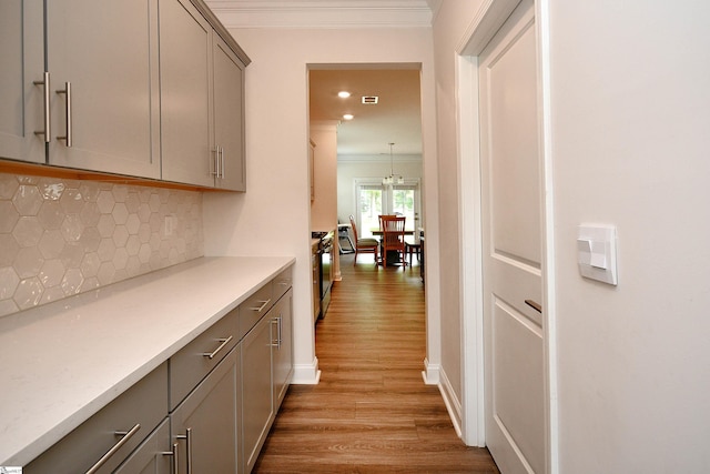 corridor with recessed lighting, light wood-type flooring, baseboards, and ornamental molding