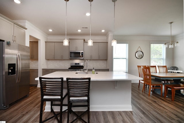 kitchen featuring stainless steel appliances, dark hardwood / wood-style flooring, decorative backsplash, an island with sink, and sink