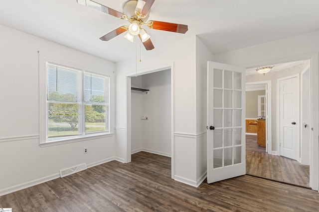 unfurnished bedroom with ceiling fan, dark hardwood / wood-style flooring, and a closet