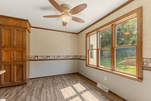 unfurnished room featuring ornamental molding, ceiling fan, and light wood-type flooring