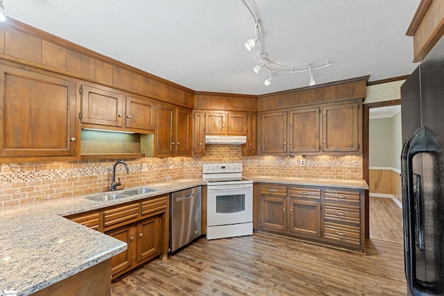 kitchen with black refrigerator, wood-type flooring, sink, stainless steel dishwasher, and white electric range oven