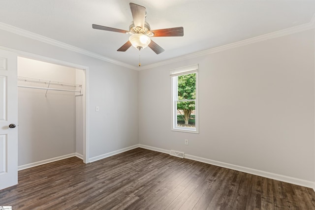 unfurnished bedroom with crown molding, dark hardwood / wood-style floors, a closet, and ceiling fan