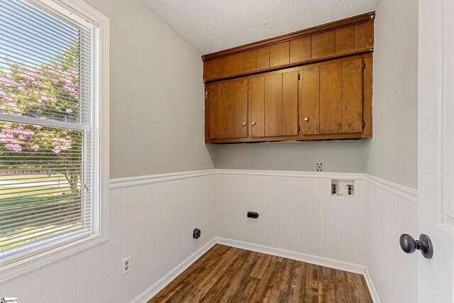 laundry area with cabinets, washer hookup, wood-type flooring, a textured ceiling, and hookup for an electric dryer