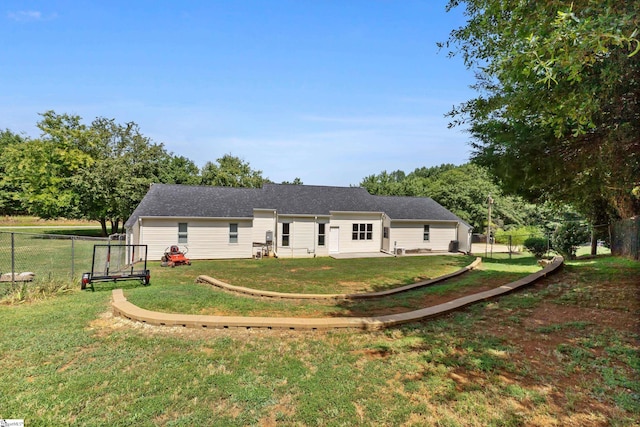 rear view of property featuring a lawn