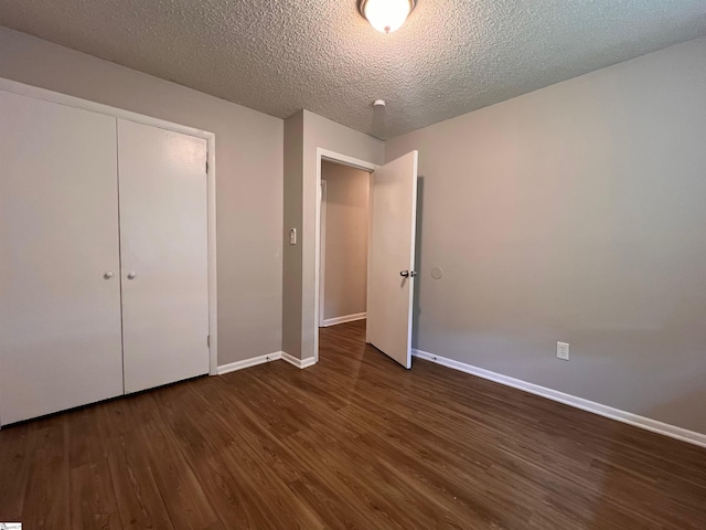 unfurnished bedroom featuring dark wood-type flooring, a closet, and a textured ceiling