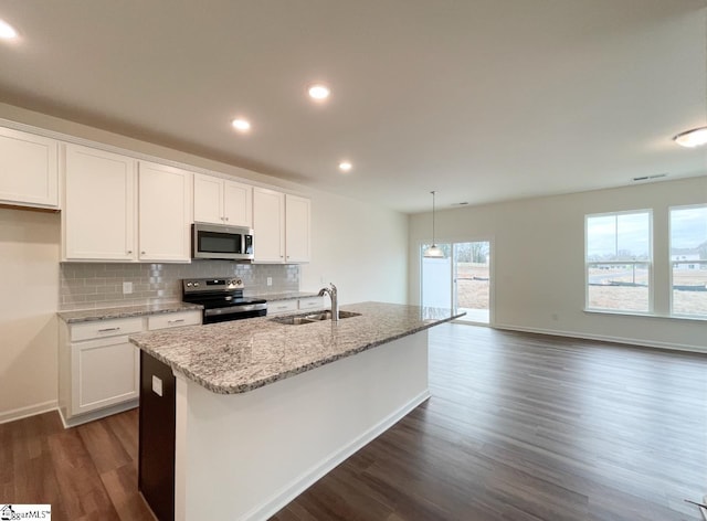 kitchen with dark wood-type flooring, a center island with sink, sink, white cabinetry, and stainless steel appliances