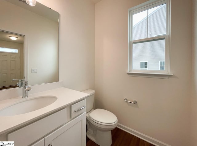 bathroom featuring toilet, vanity, and hardwood / wood-style flooring