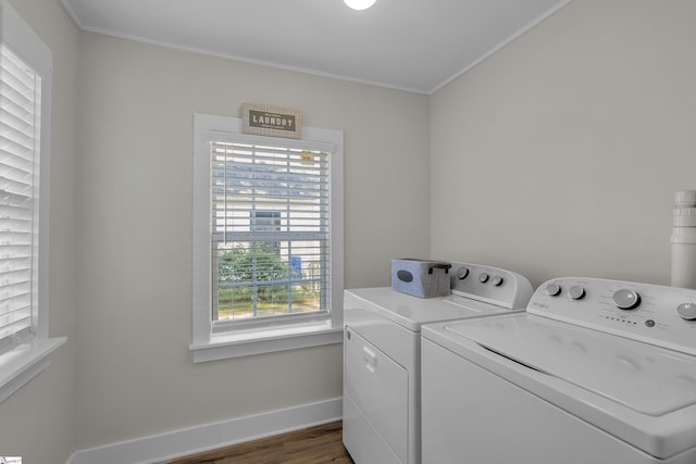 washroom featuring laundry area, baseboards, wood finished floors, crown molding, and washer and dryer