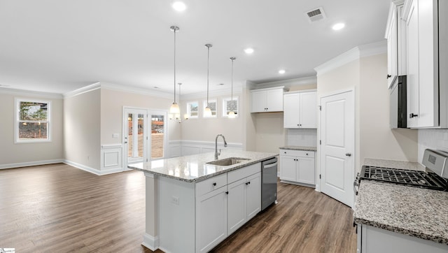 kitchen featuring stainless steel appliances, white cabinets, a kitchen island with sink, and a sink