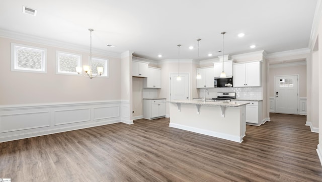 kitchen featuring stainless steel electric range oven, visible vents, a kitchen island with sink, white cabinets, and black microwave