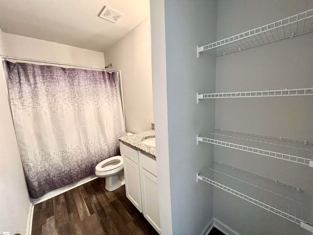 bathroom with vanity, hardwood / wood-style flooring, and toilet