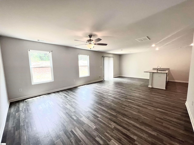 unfurnished living room with dark hardwood / wood-style flooring, sink, and ceiling fan