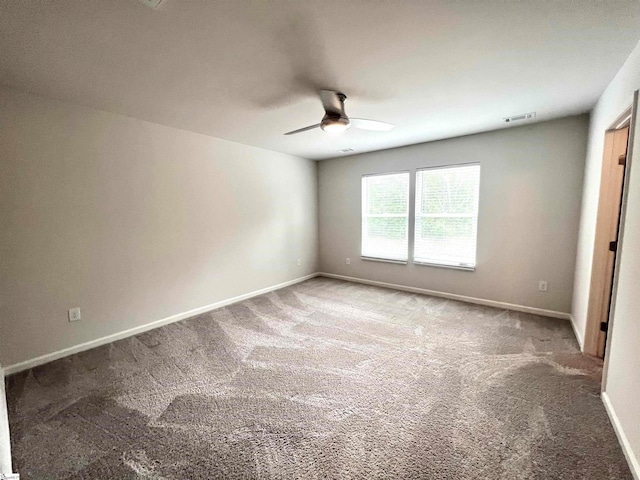 carpeted spare room featuring ceiling fan