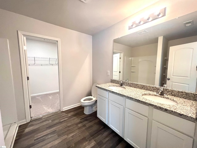 bathroom with hardwood / wood-style floors, toilet, and dual bowl vanity