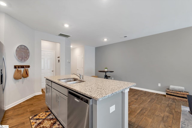 kitchen featuring sink, dark wood-type flooring, gray cabinetry, stainless steel appliances, and an island with sink