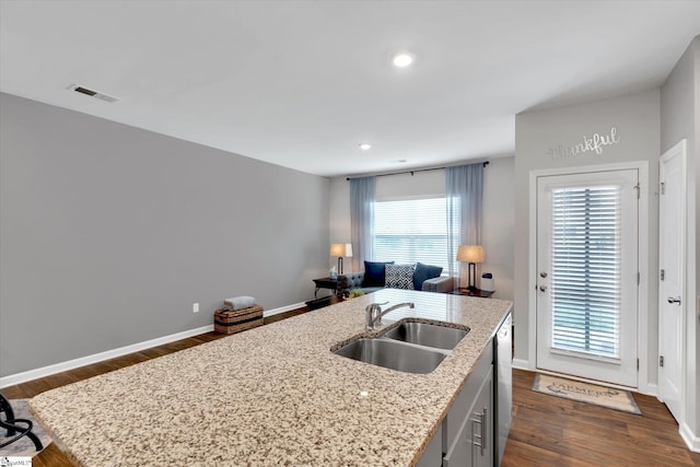 kitchen with a kitchen island with sink, sink, dishwasher, and a wealth of natural light