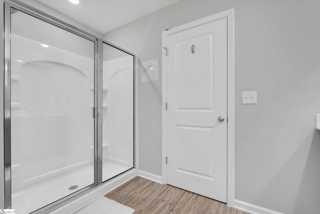 bathroom featuring hardwood / wood-style flooring and a shower with door