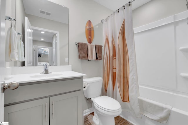 full bathroom with vanity, hardwood / wood-style floors, toilet, and shower / bath combo with shower curtain