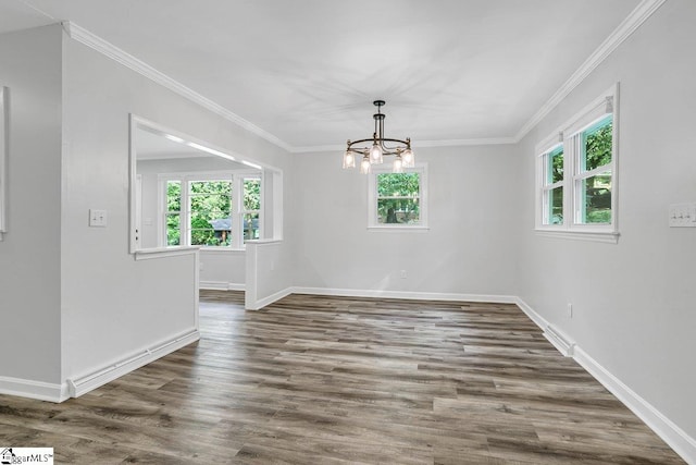 unfurnished dining area featuring dark wood-type flooring, crown molding, and a chandelier