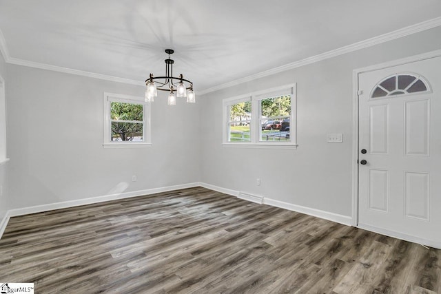 unfurnished dining area featuring wood-type flooring, an inviting chandelier, and crown molding