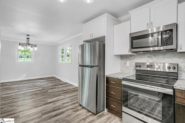 kitchen featuring appliances with stainless steel finishes, white cabinets, and light stone countertops