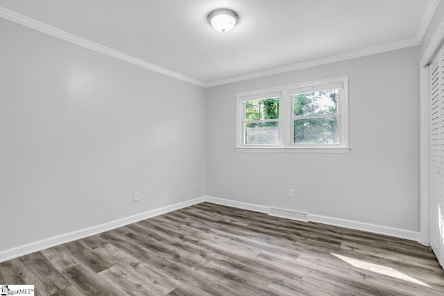 empty room featuring ornamental molding and wood-type flooring