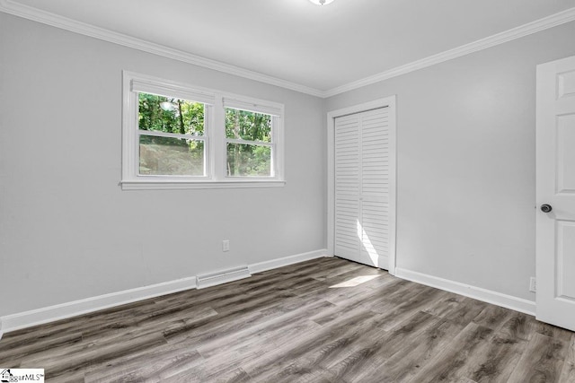 unfurnished bedroom featuring a closet, ornamental molding, and dark hardwood / wood-style flooring