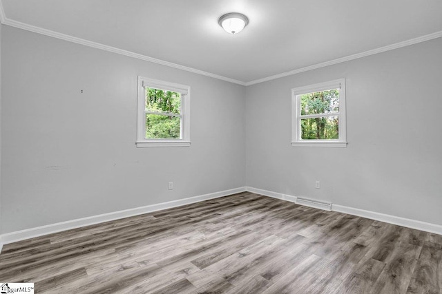 spare room featuring crown molding and light hardwood / wood-style flooring