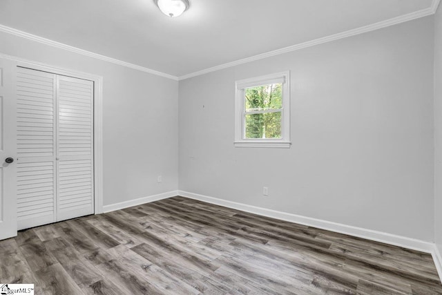 unfurnished bedroom featuring a closet, ornamental molding, and hardwood / wood-style floors