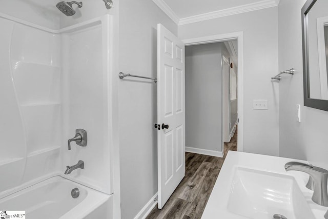 bathroom featuring hardwood / wood-style flooring, sink, bathtub / shower combination, and crown molding