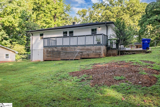 rear view of property featuring a deck and a yard