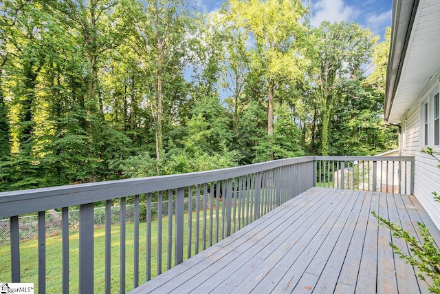 wooden terrace featuring a yard