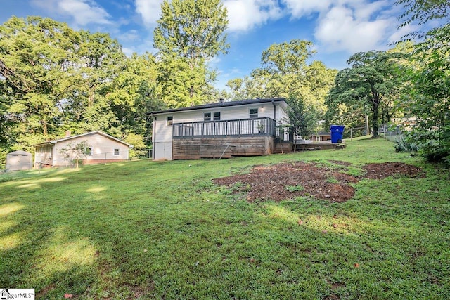 rear view of property with a deck and a lawn