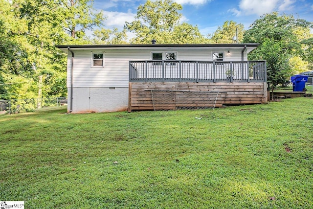 back of house featuring a deck and a yard